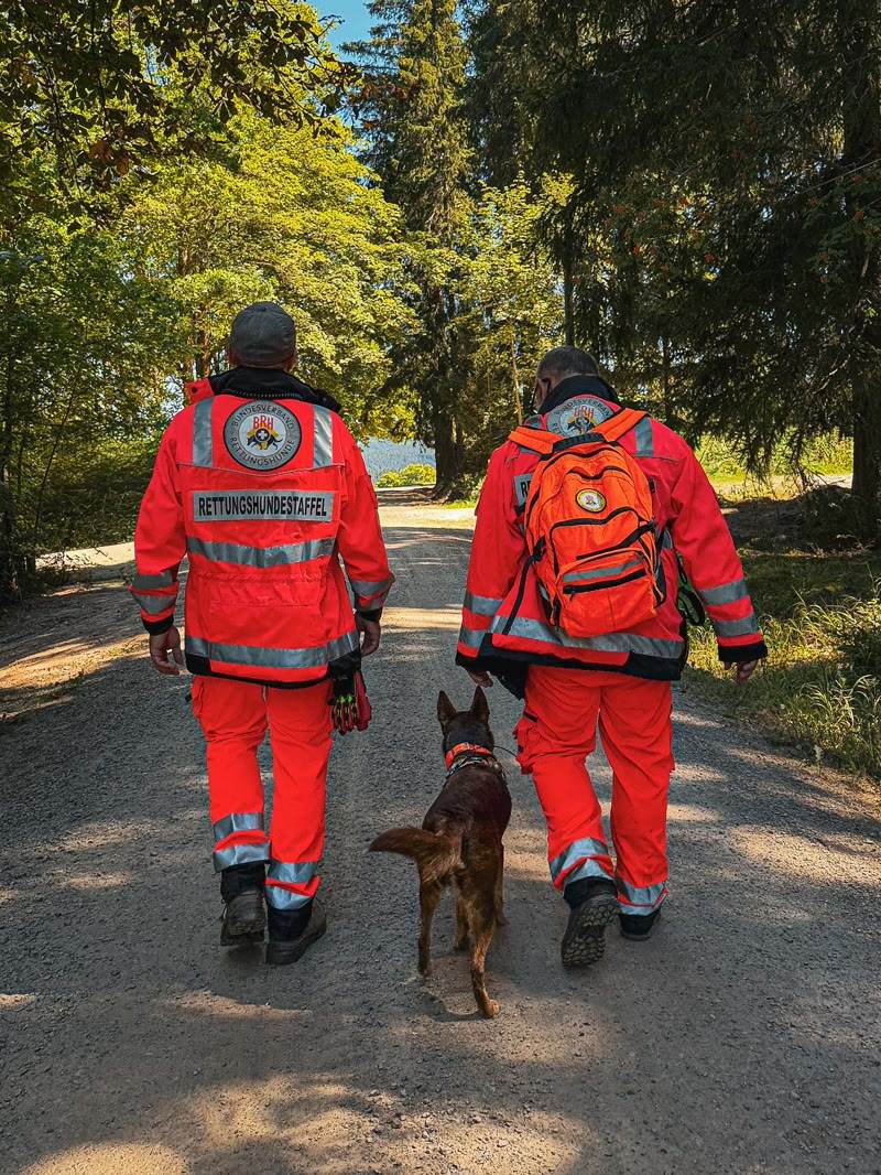 Zwei Mitglieder der Rettungshundestaffel mit Hund im Wald